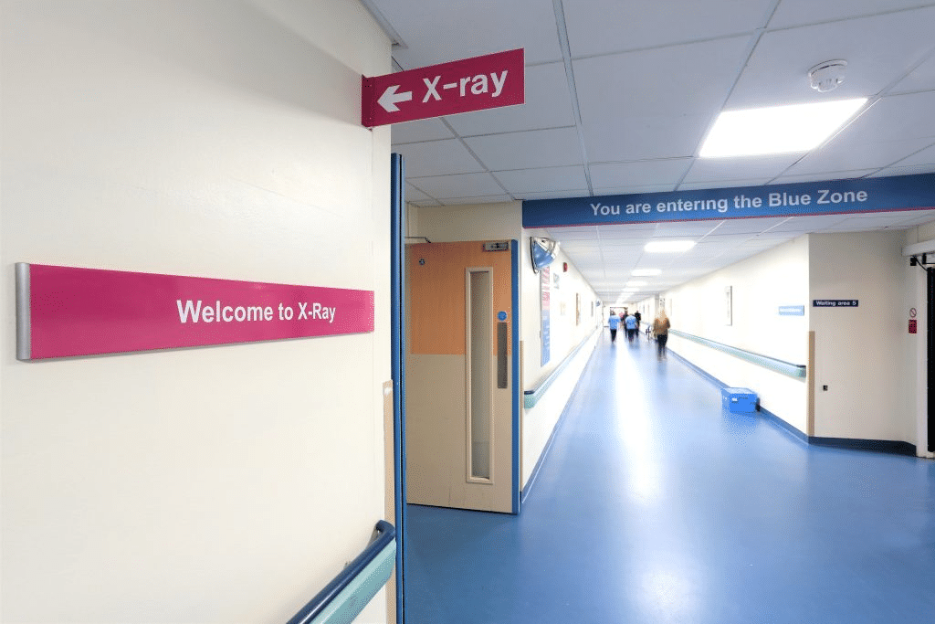Hospital corridor with X-ray department signs and colour-coded wayfinding
